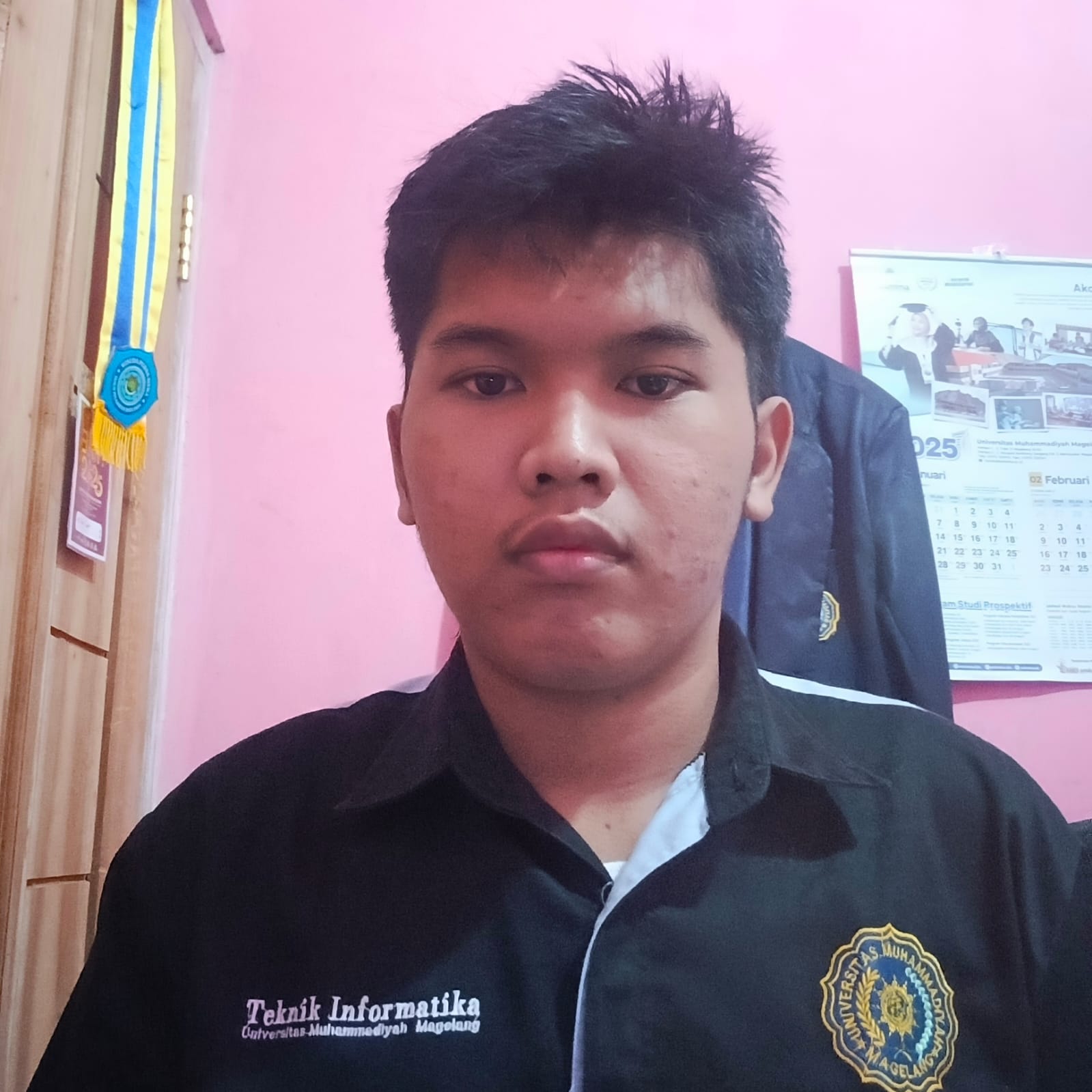 Mahasiswa Teknik Informatika UNIMMA pria mengangkat sertifikat dengan senyum bangga di aula kampus